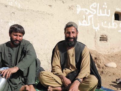 Two men sitting in front of a wall in Helmand Province